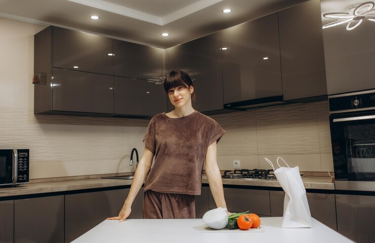 woman stands in kitchen 