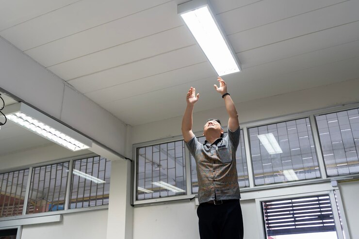 Man Changing Light Bulb in Office Arear